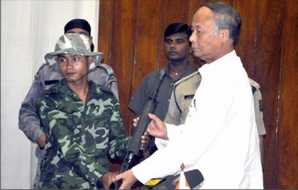 A cadre hands over a gun to the Chief Minister