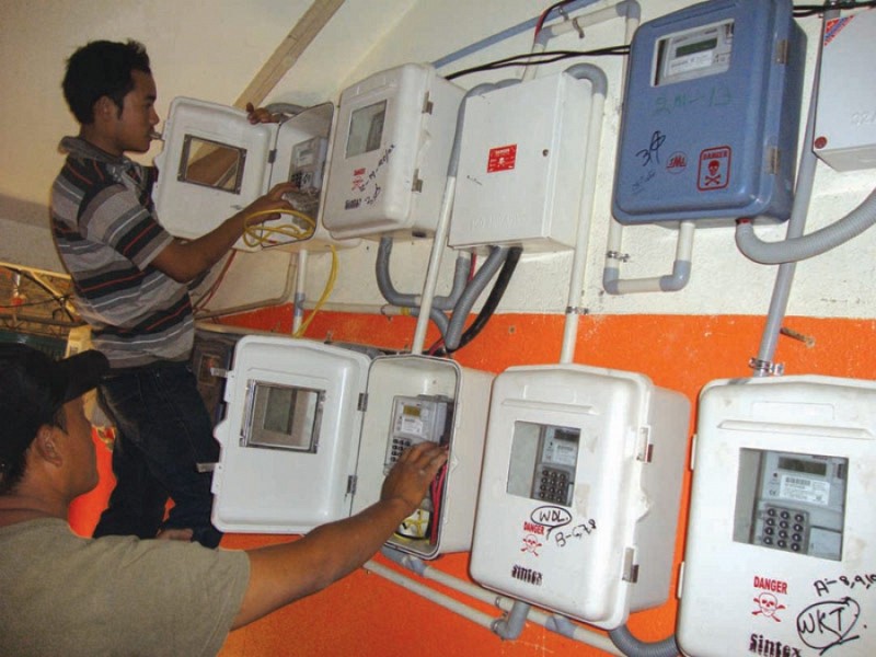 Staffs of Power Dept installing pre-paid power meters  