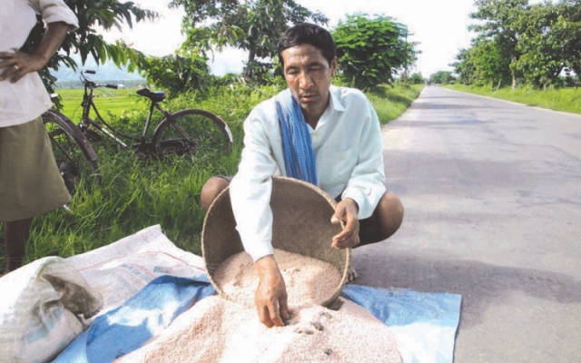 A farmer showing the stones found inside the fertiliser bags provided by state govt.